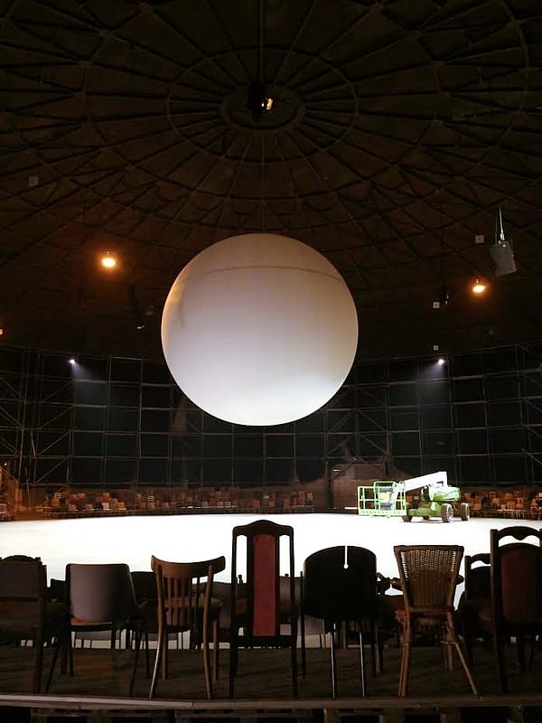 single white ball on stage with empty chairs