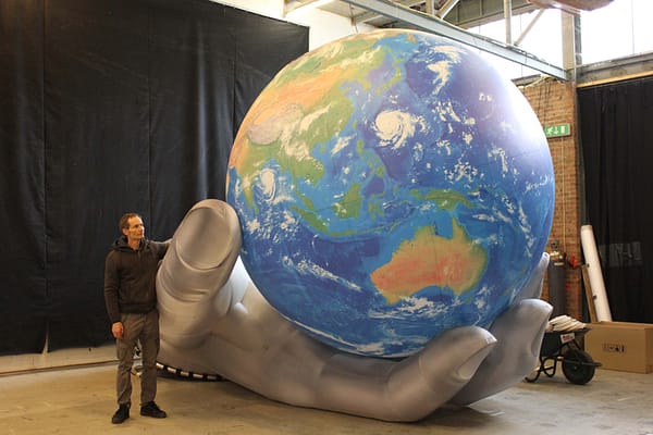 2.5m printed globe with silver hand in studio